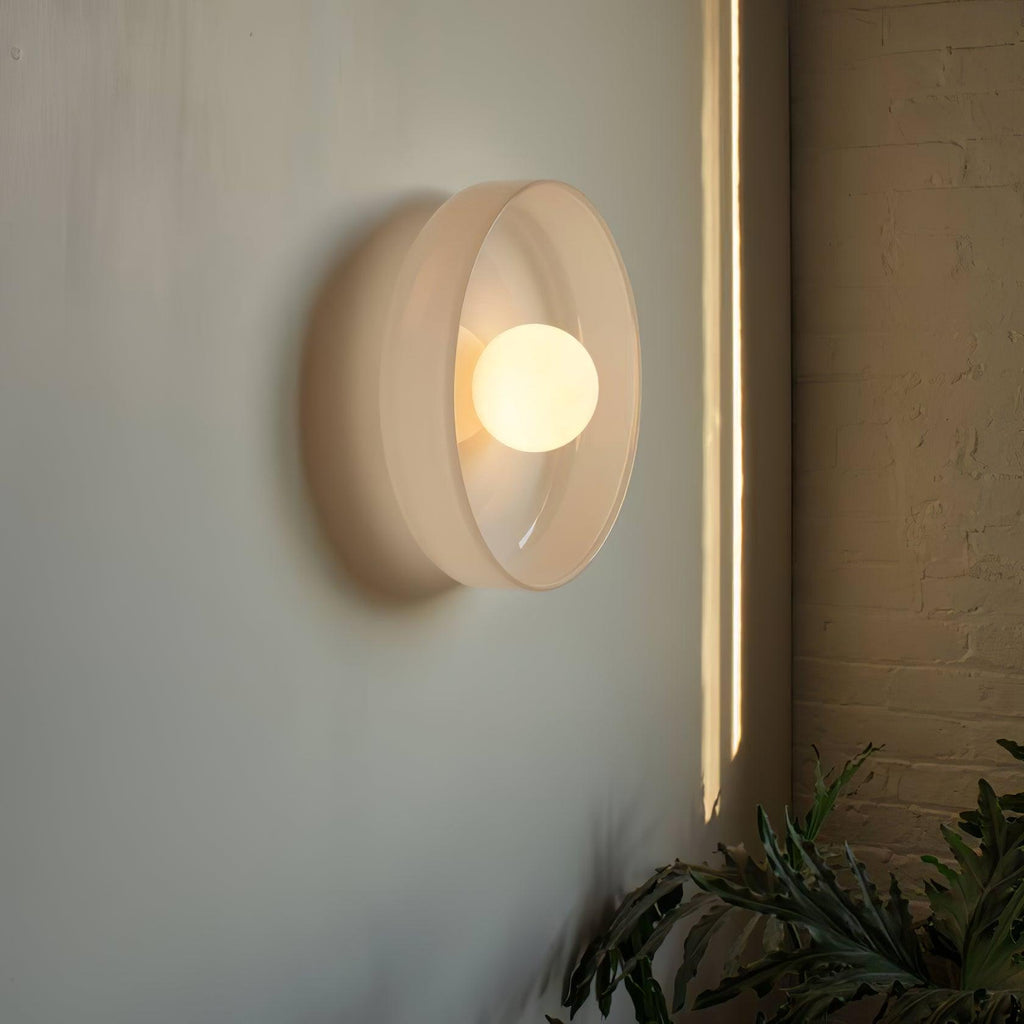 A cream disc-shaped wall light beside a vertical light strip on a brick wall, a different fixture from this Clérachic ceiling light.