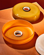 Close view of two brown glass shade rings from this Clérachic ceiling light, shown as loose parts on a warm-toned surface.