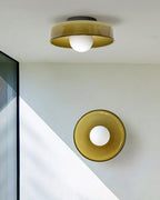 This Clérachic ceiling light and a matching wall light sit together in a stairwell corner, in warm brown glass.