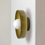A brown-toned disc wall light mounted at a wall's edge, a different fixture from this Clérachic ceiling light.