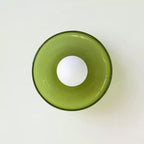 A green disc-shaped wall light with its ball centred in the ring, a different fixture from this Clérachic ceiling light.