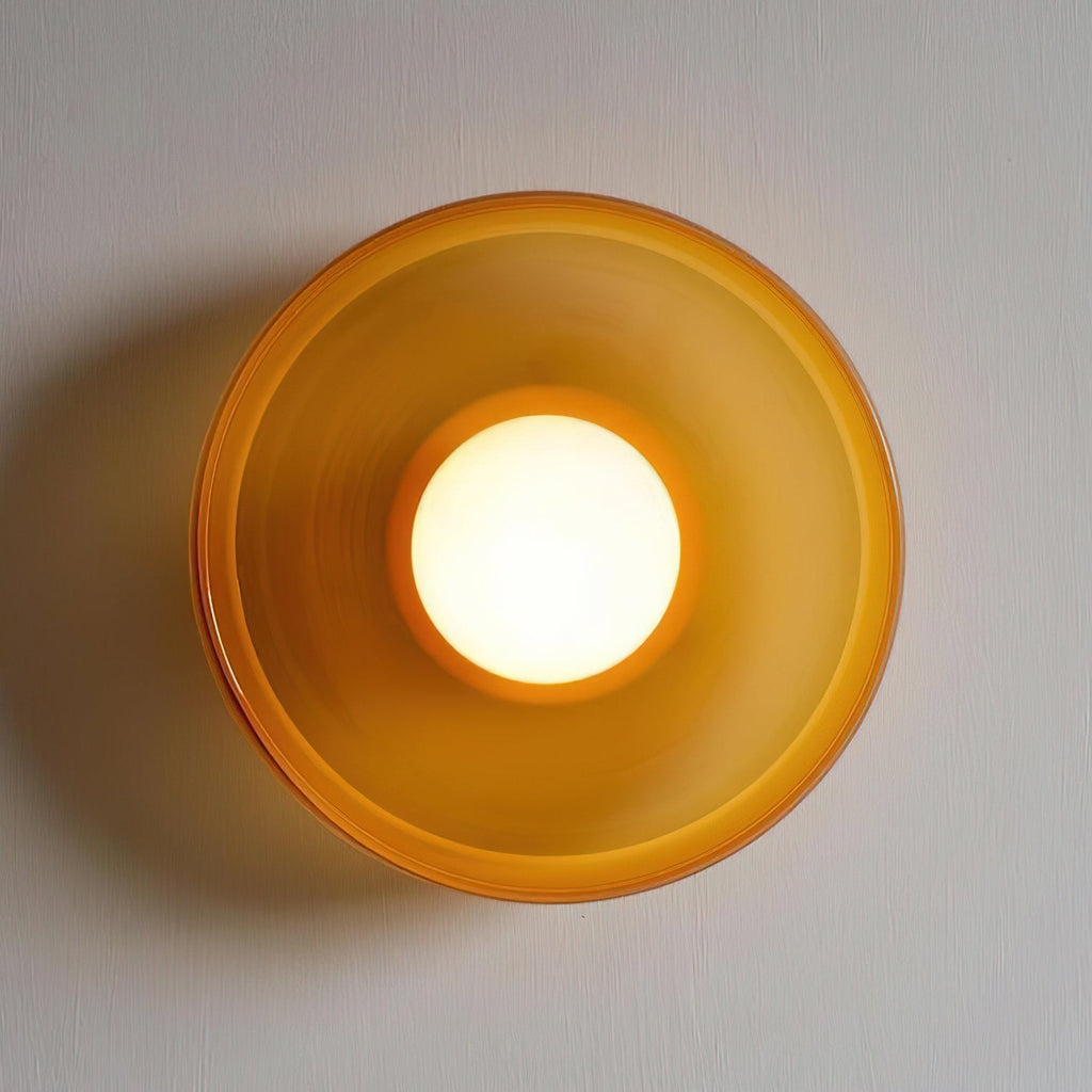 A large orange wall light shown close up with its ball lit, a different fixture from this Clérachic ceiling light.