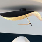 Curved disc ceiling light glowing softly in a corner