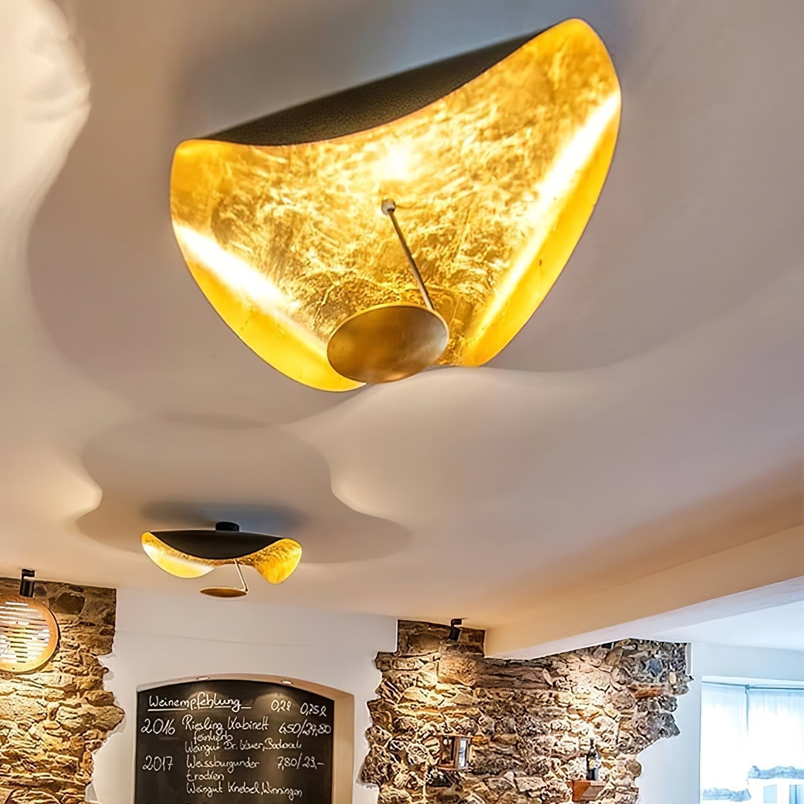 Curved steel disc ceiling light above a styled room