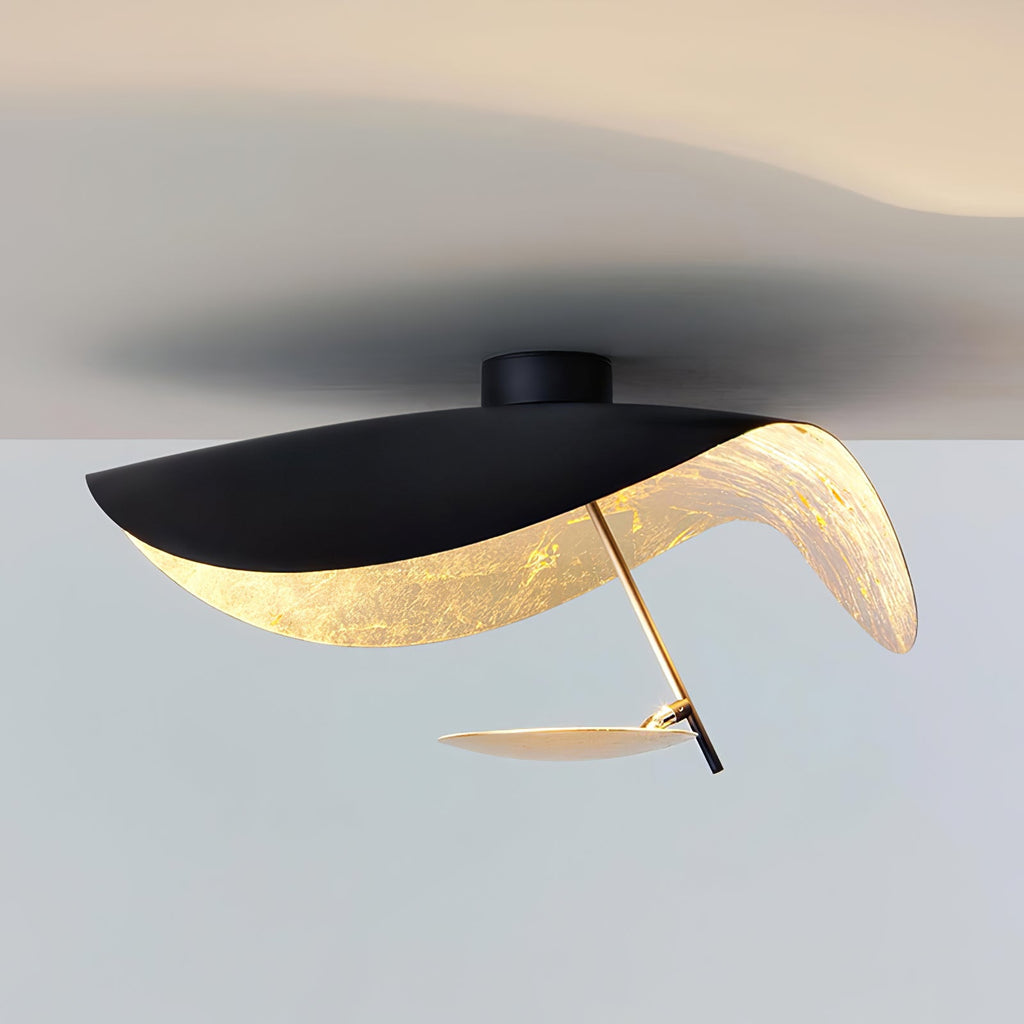 Curved steel disc ceiling light in a minimal room
