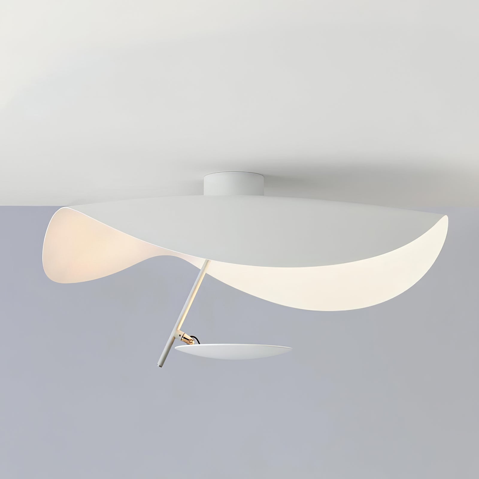 Curved steel disc ceiling light lit warm overhead