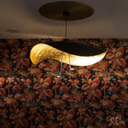 White disc pendant light glowing softly above a table