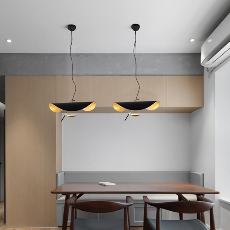 Curved disc pendant light shown as a sculptural ceiling piece