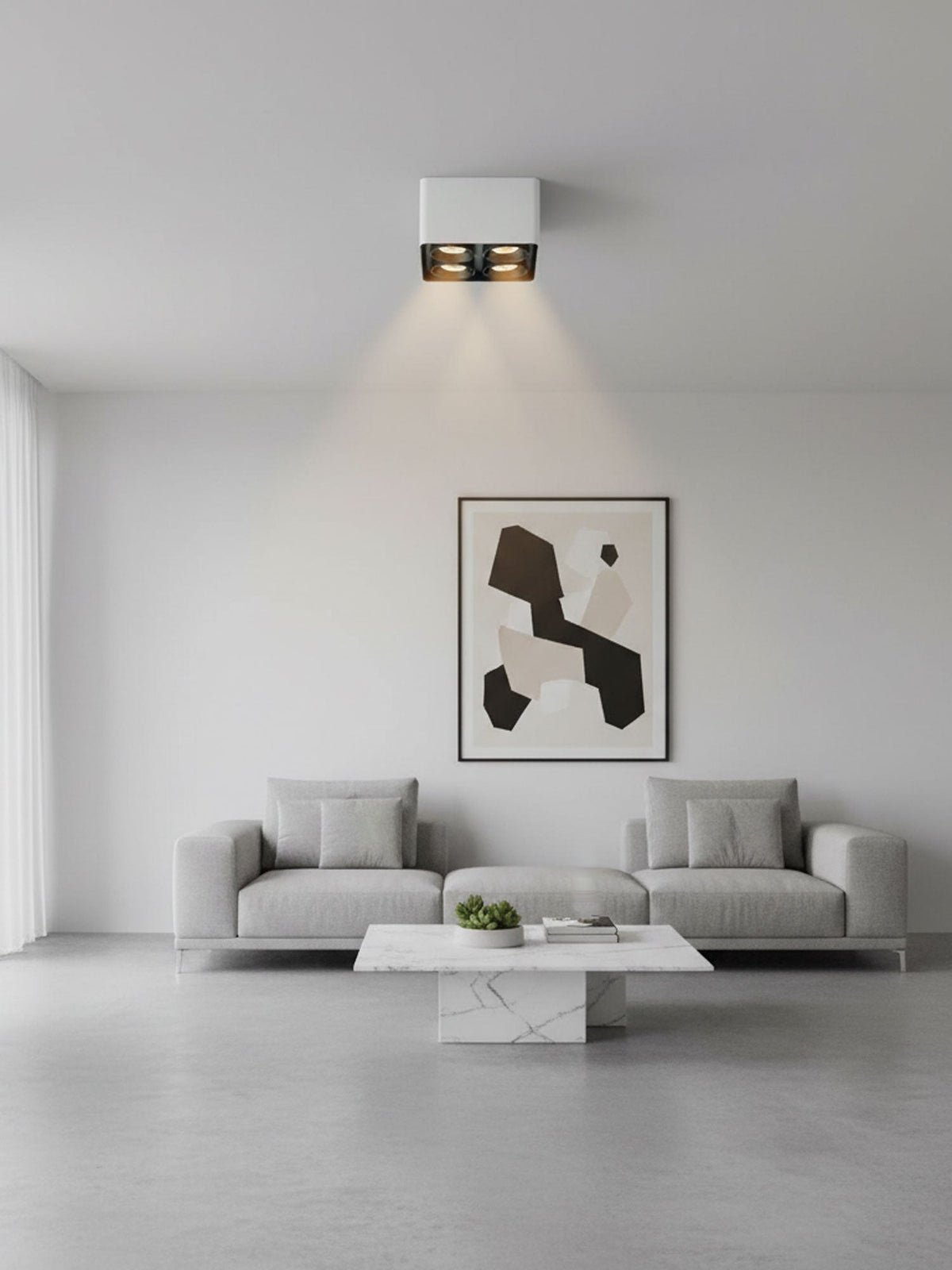 Above a living room sofa and framed print, a white two-light Clérachic spotlight glows warm on the ceiling.