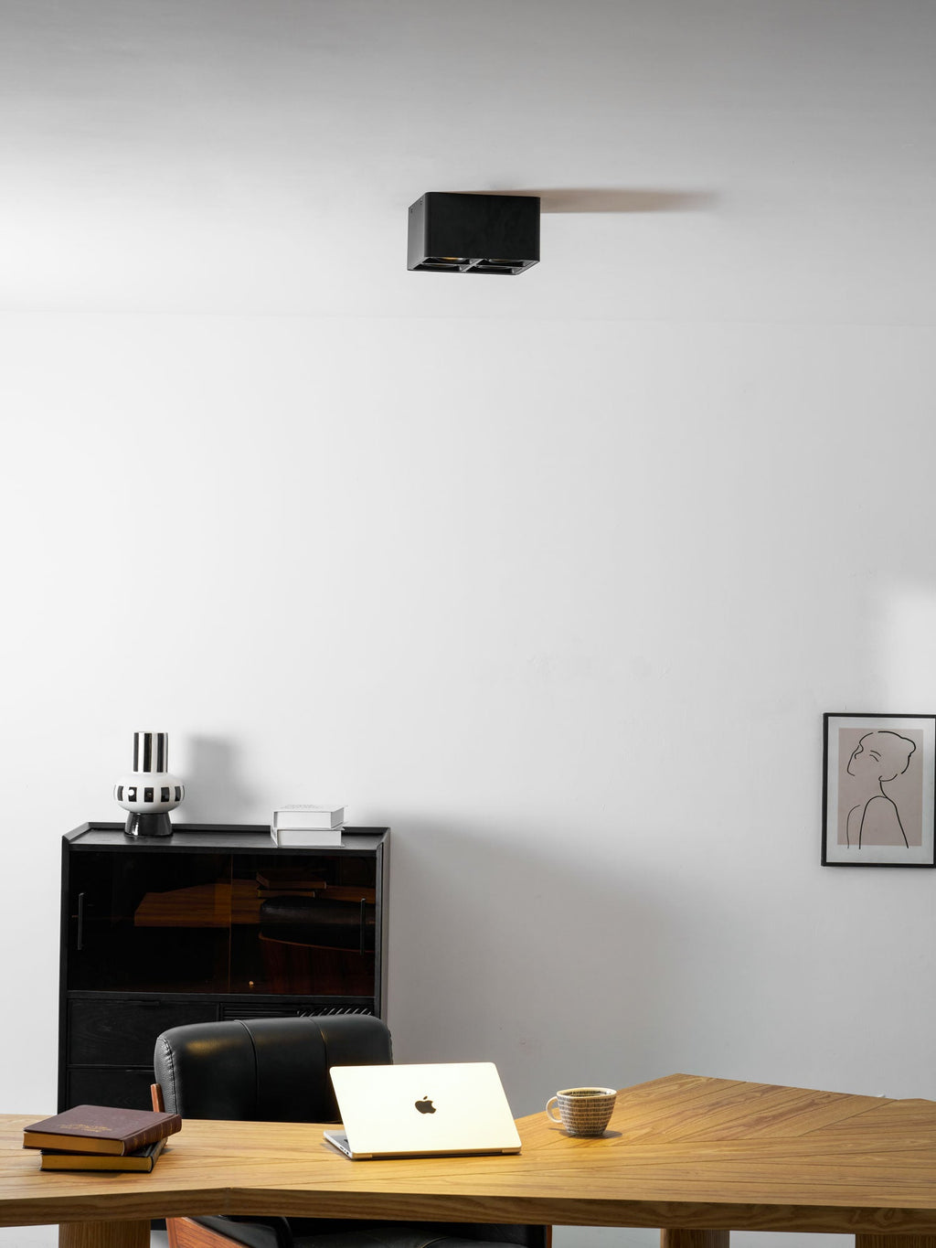 A closer view of the same office ceiling shows a single black Clérachic spotlight sitting unlit.