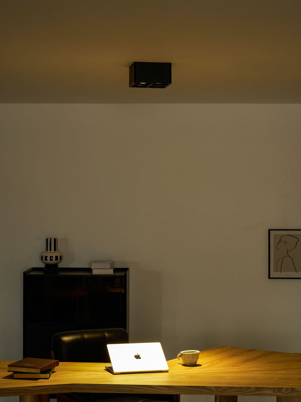 Back in the same home office, a single black Clérachic spotlight glows warm on the ceiling above the desk.