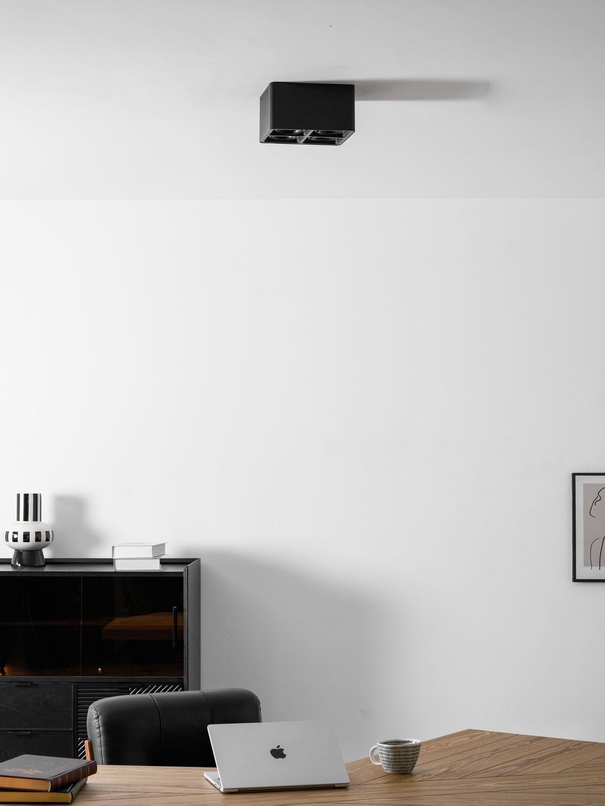 In the same office setting, a black two-light Clérachic spotlight sits unlit on the ceiling.