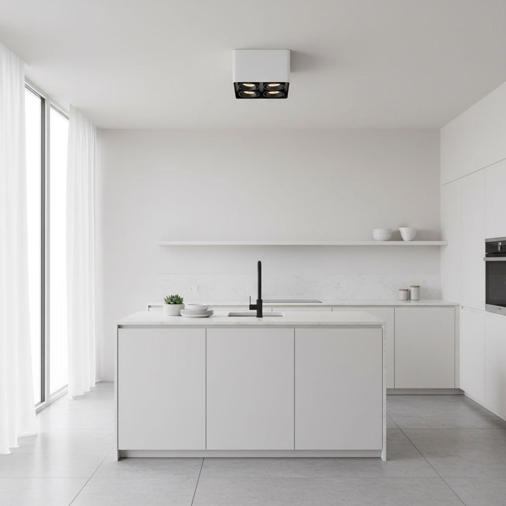 In a bright white kitchen, a white two-light Clérachic spotlight glows warm from the ceiling.