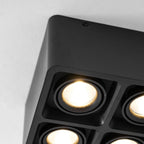 Close view of four lamp lenses on this black Clérachic spotlight, unlit, showing the textured reflector detail.
