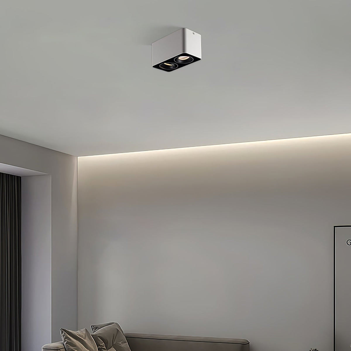 Above a bed beside an indirect light strip, a white two-light Clérachic spotlight sits unlit on the ceiling.