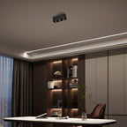 Above dark wood shelving and an indirect light strip, a black two-light Clérachic spotlight sits unlit on the ceiling.