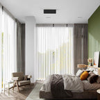 In a bedroom with sheer curtains and a green accent wall, a black Clérachic spotlight sits unlit on the ceiling.