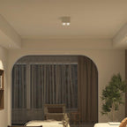 Beneath a decorative archway, a white two-light Clérachic spotlight glows warm above a dining table.