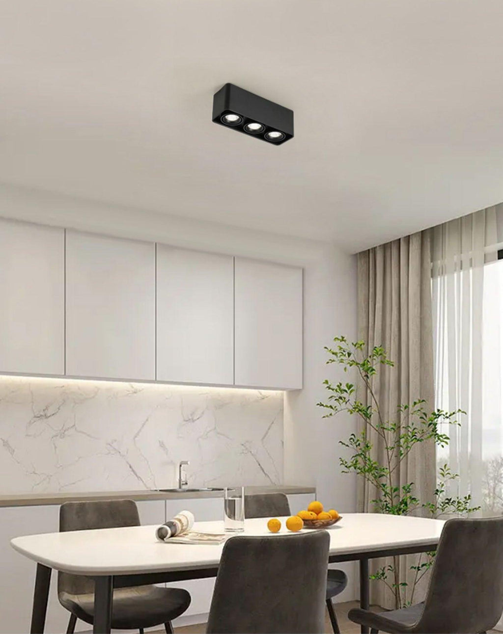 In a kitchen with a marble backsplash, a black two-light Clérachic spotlight sits unlit above the dining table.