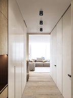 Along a wood-panelled hallway, three black single-light Clérachic spotlights sit unlit in a row on the ceiling.