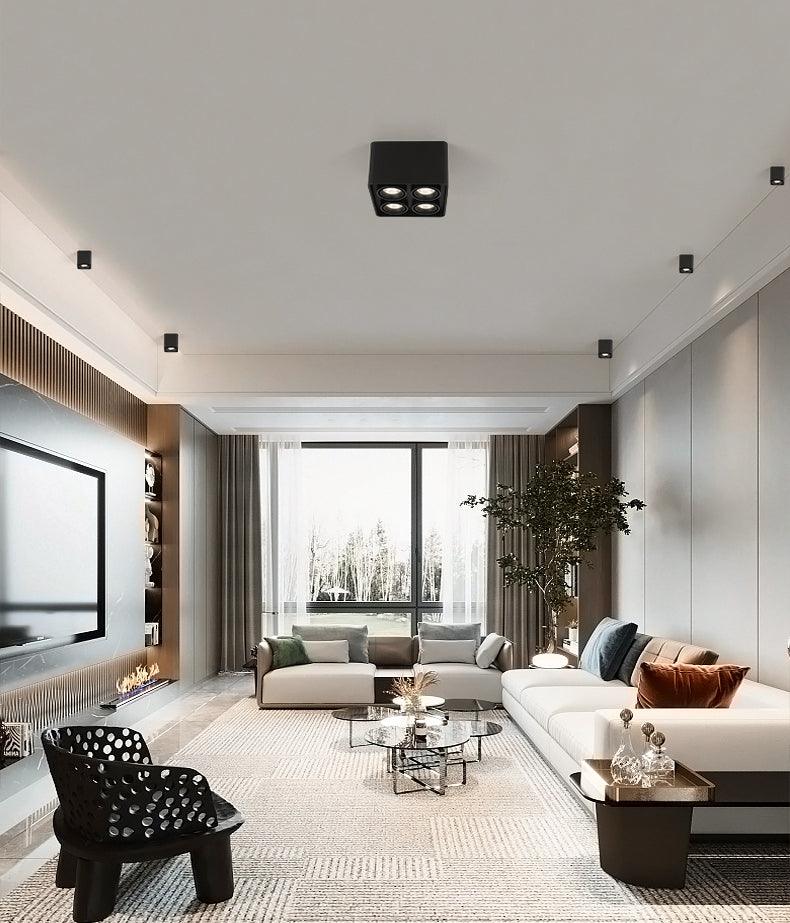 Above a sculptural chair and floor-to-ceiling window, a black two-light Clérachic spotlight sits unlit on the ceiling.