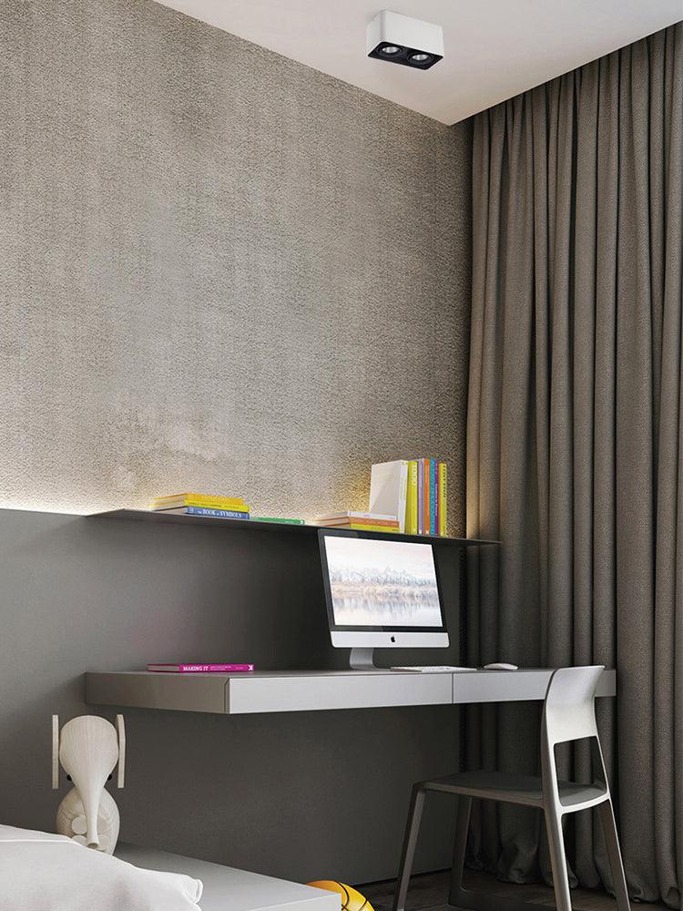 Above a desk with a monitor, a white single-light Clérachic spotlight sits unlit on the ceiling.