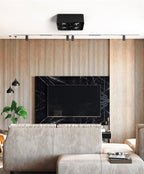 Against a wood-slat wall near a television, a black two-light Clérachic spotlight sits unlit on the ceiling.