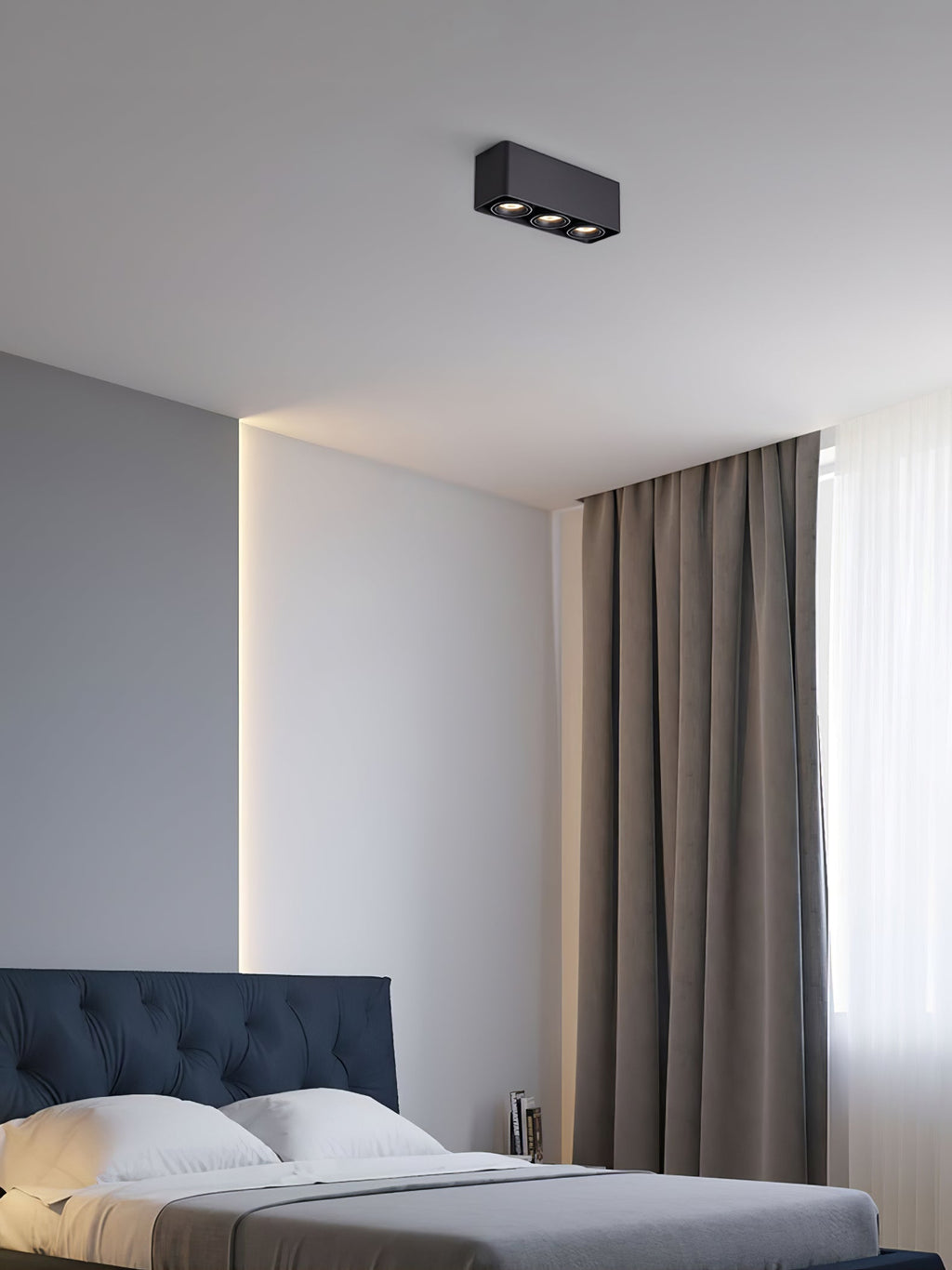 Above a dark blue headboard and indirect light strip, a black two-light Clérachic spotlight sits unlit on the ceiling.