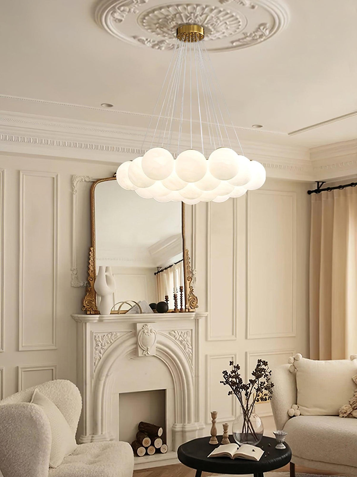Above a marble fireplace and upholstered armchair, this lit Clérachic cluster chandelier hangs from an ornate ceiling medallion.