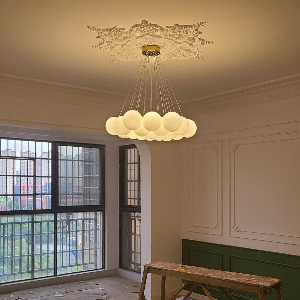 Lit warmly, this Clérachic cluster chandelier hangs from an ornate ceiling medallion in a sunlit, unfinished room.