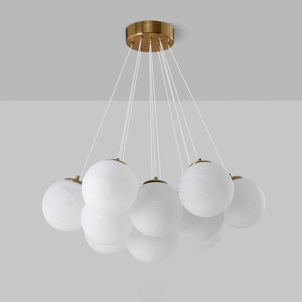 Against a two-tone grey backdrop, this Clérachic cluster chandelier shows gold caps fitted to each frosted glass globe.