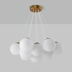 Against a two-tone grey backdrop, this Clérachic cluster chandelier shows gold caps fitted to each frosted glass globe.