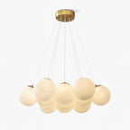 On a white background, this Clérachic cluster chandelier shows its frosted glass globes gathered beneath a gold ceiling plate.
