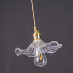 Clear fluted glass hibiscus pendant light against dark backdrop