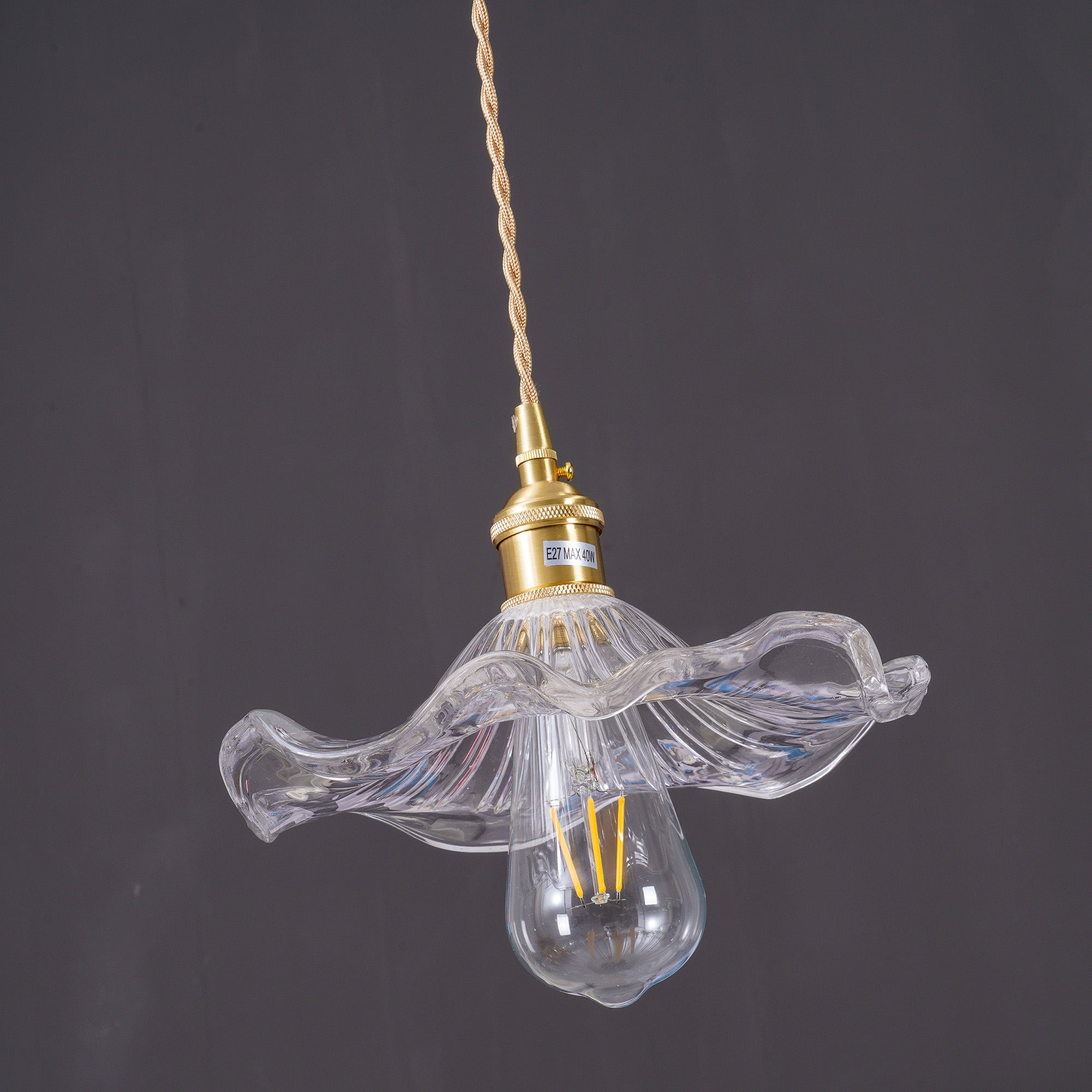Clear fluted glass hibiscus pendant light against dark backdrop