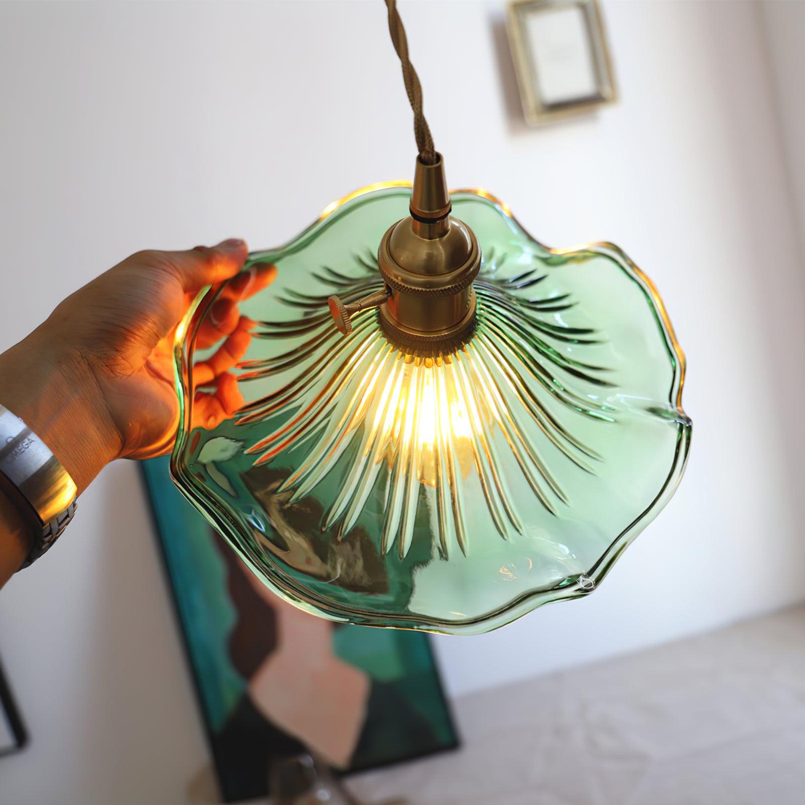Fluted glass hibiscus swag light with brushed brass holder lit
