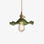 Hibiscus glass pendant light shown lit against a dark wall