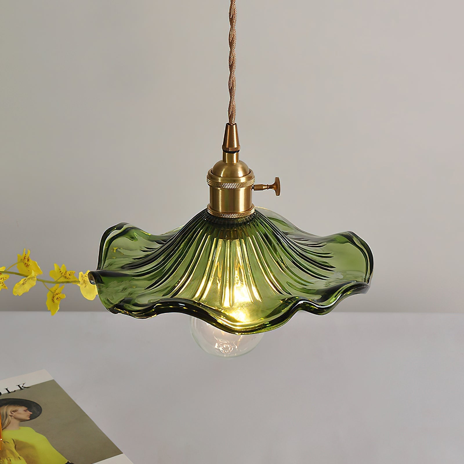Close detail of fluted hibiscus glass shade and brass holder