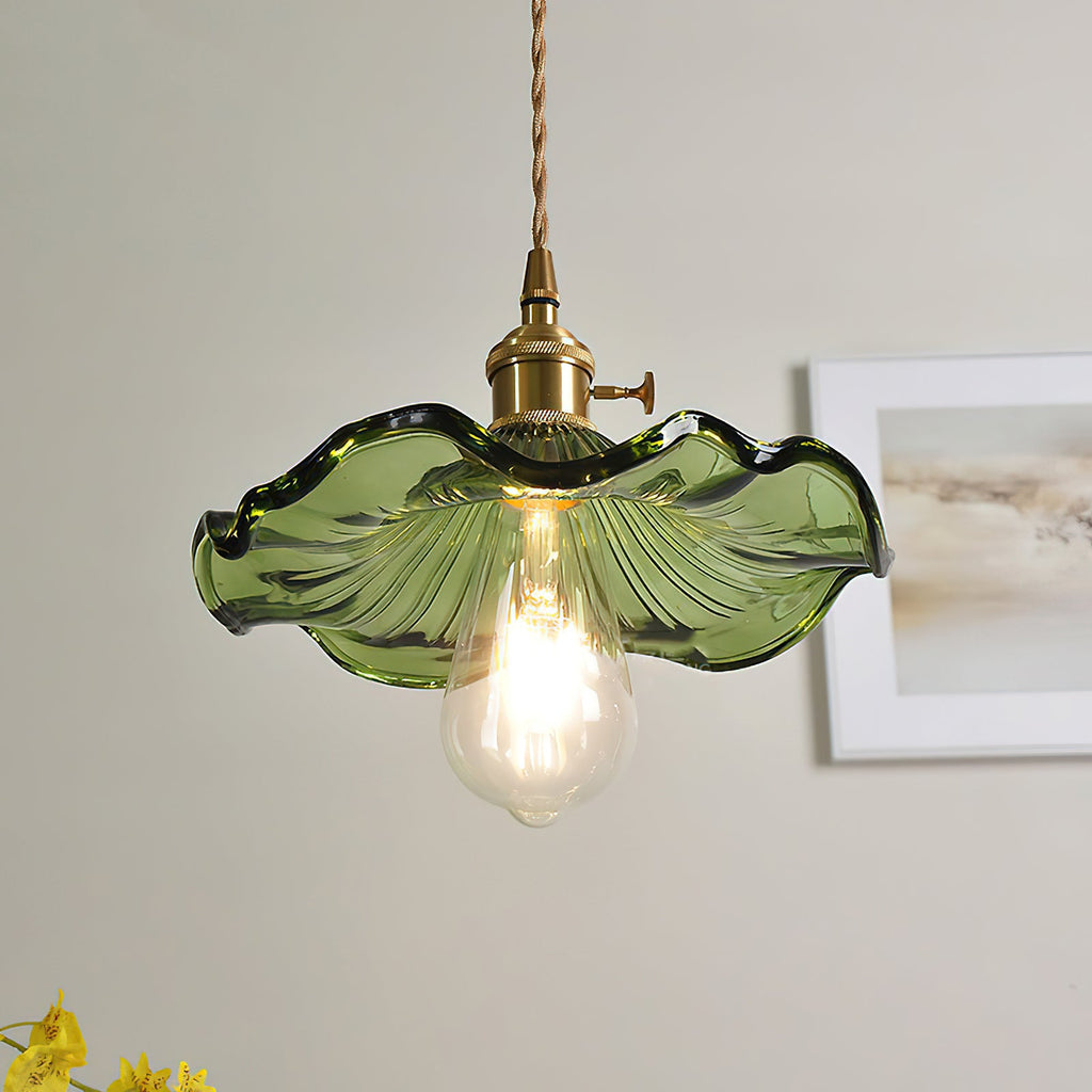 Brass hibiscus pendant light hanging above a styled table