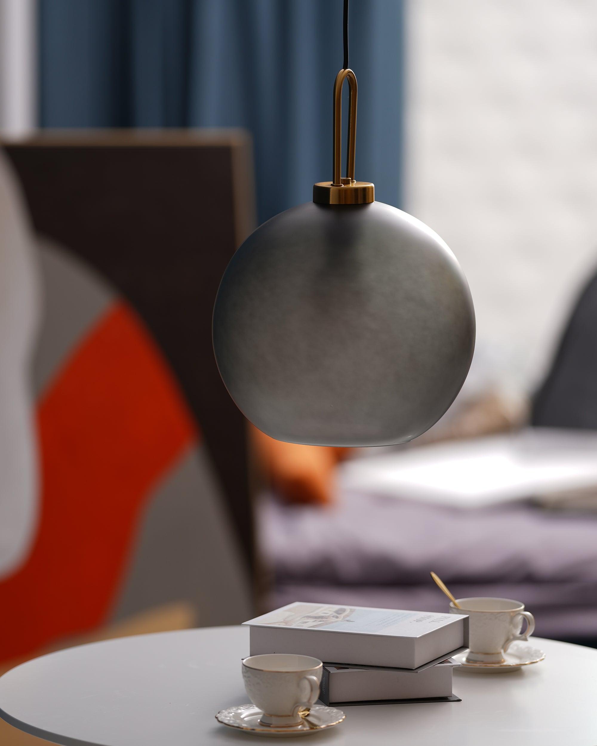 Glass pendant light glowing warmly in a styled living space