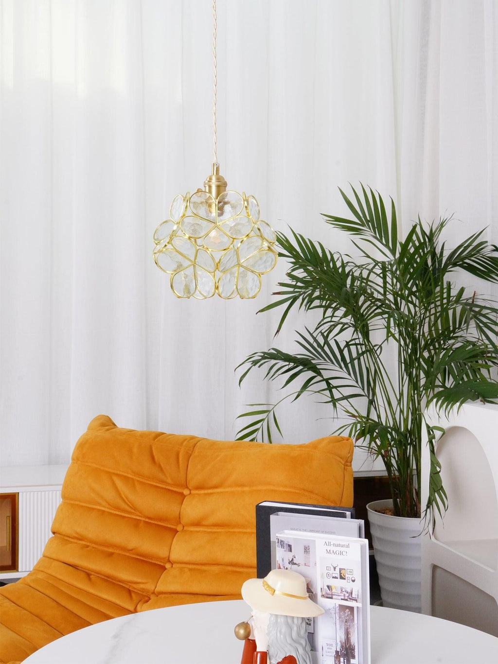 Handblown glass petal pendant light glowing over a counter