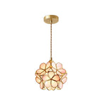 Glass petal pendant light shown glowing above a table