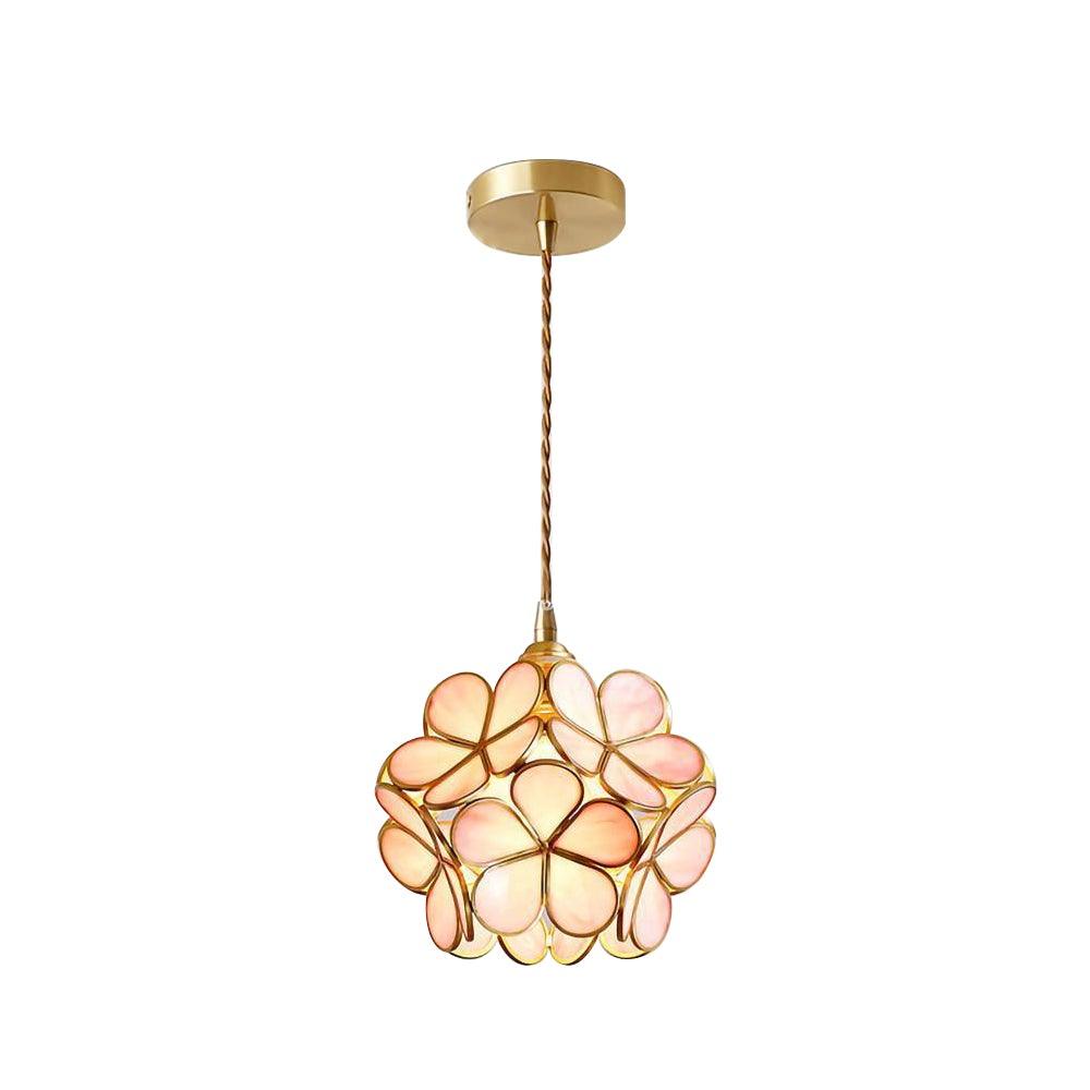 Glass petal pendant light shown glowing above a table