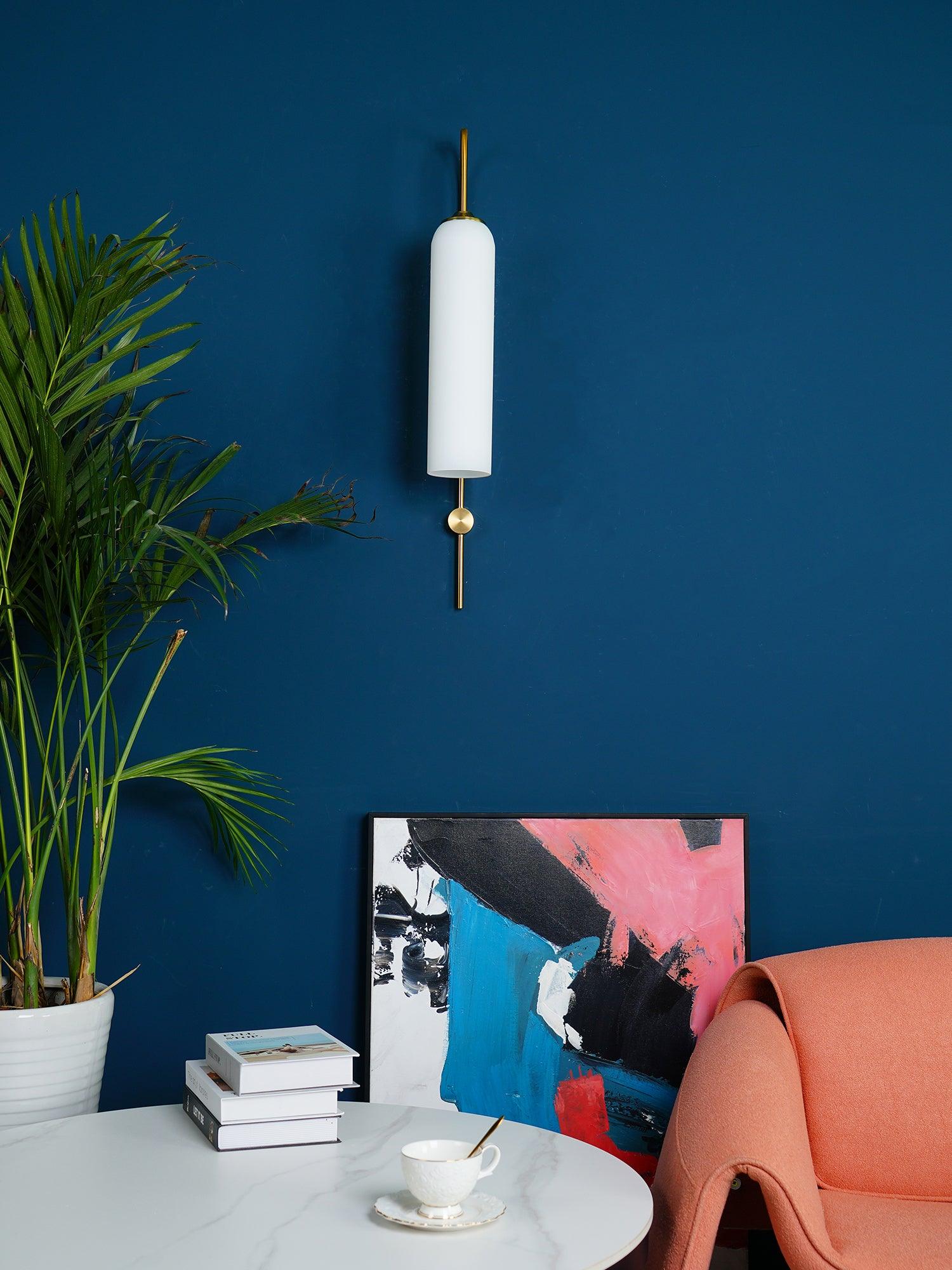 Glass wall sconce shown lit with a warm downward glow