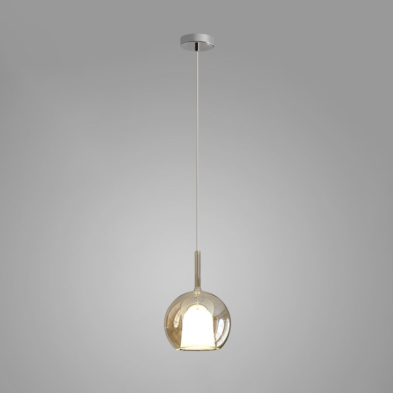 Rose gold tinted glass globe pendant light over a table