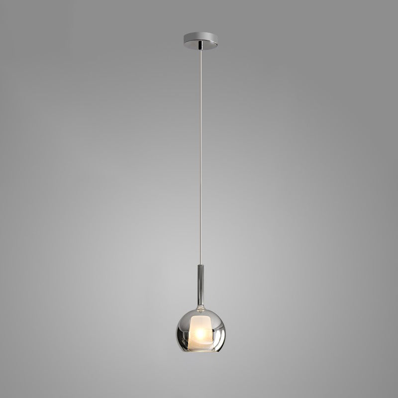 Amber glass globe pendant light glowing above a kitchen island
