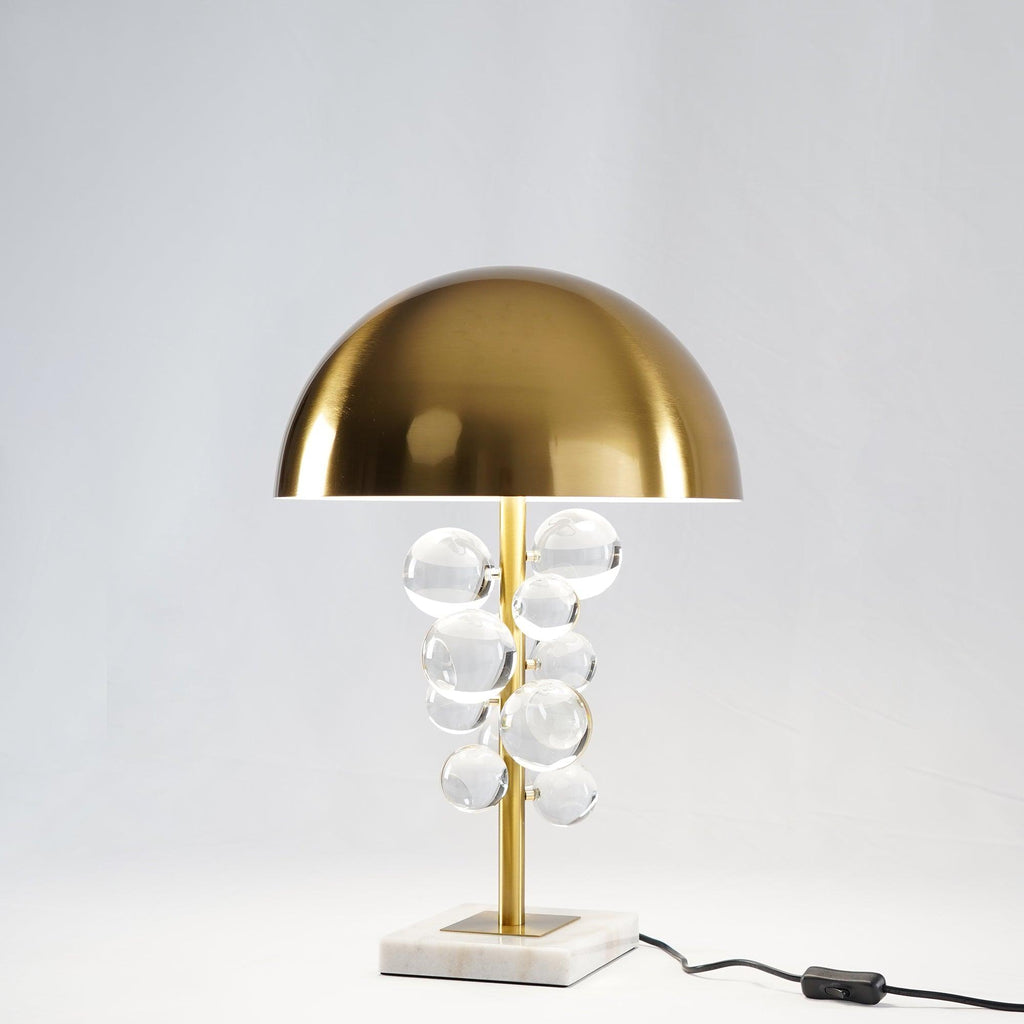 Glass sphere table lamp lit on a wood surface in a cozy room