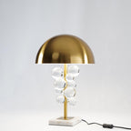 Glass sphere table lamp lit on a wood surface in a cozy room