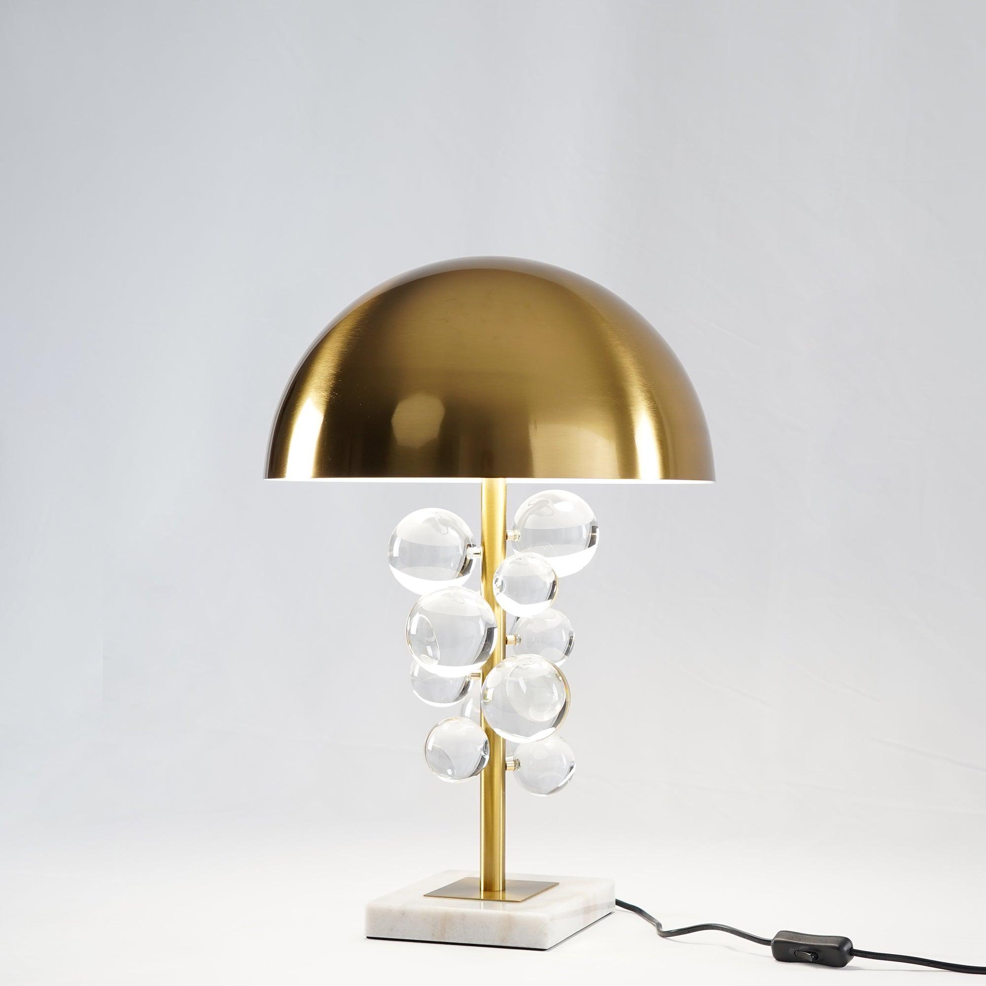 Glass sphere table lamp lit on a wood surface in a cozy room