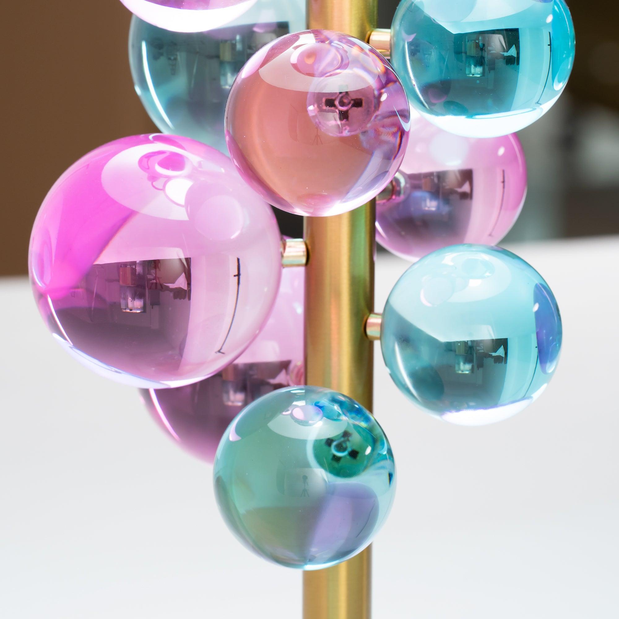 Glass sphere lamp casting kaleidoscopic light across a wall